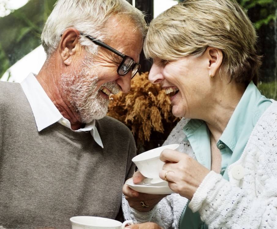 lachend echtpaar drinkt kopje koffie